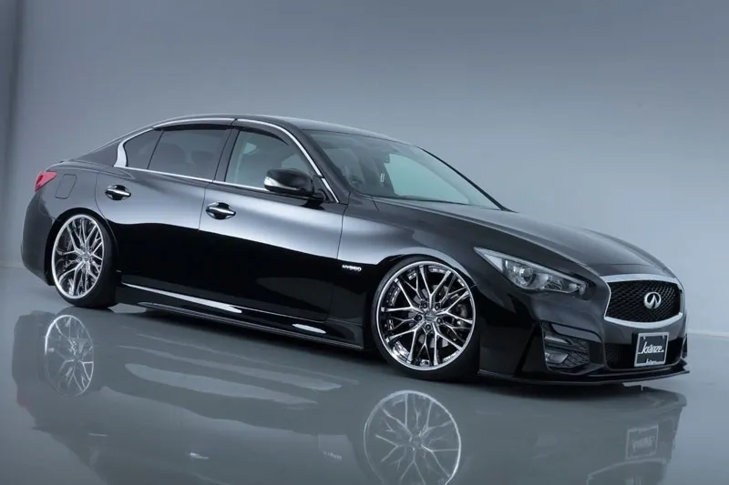 A black infiniti q 5 0 parked on top of a wet floor.