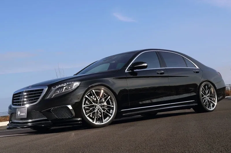 A black mercedes benz parked on the side of a road.