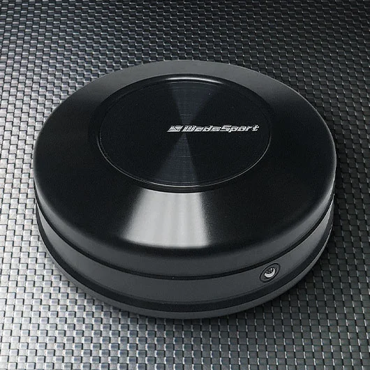 A black round speaker sitting on top of a table.