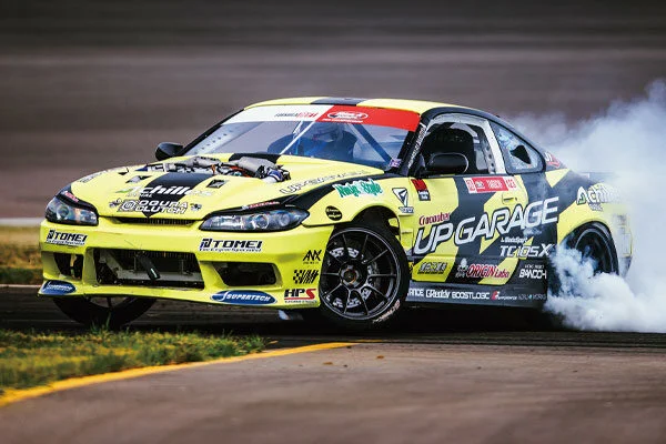 A yellow drift car is on the track
