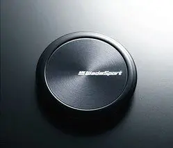 A black button on a black surface.