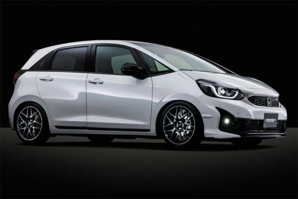The white honda jazz is shown against a black background.