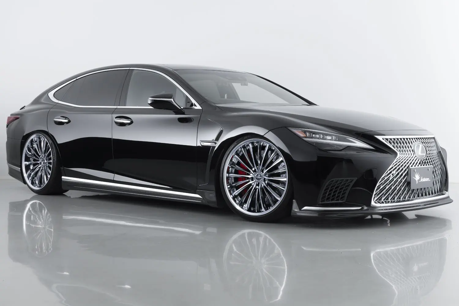 The black lexus ls is parked in a studio.