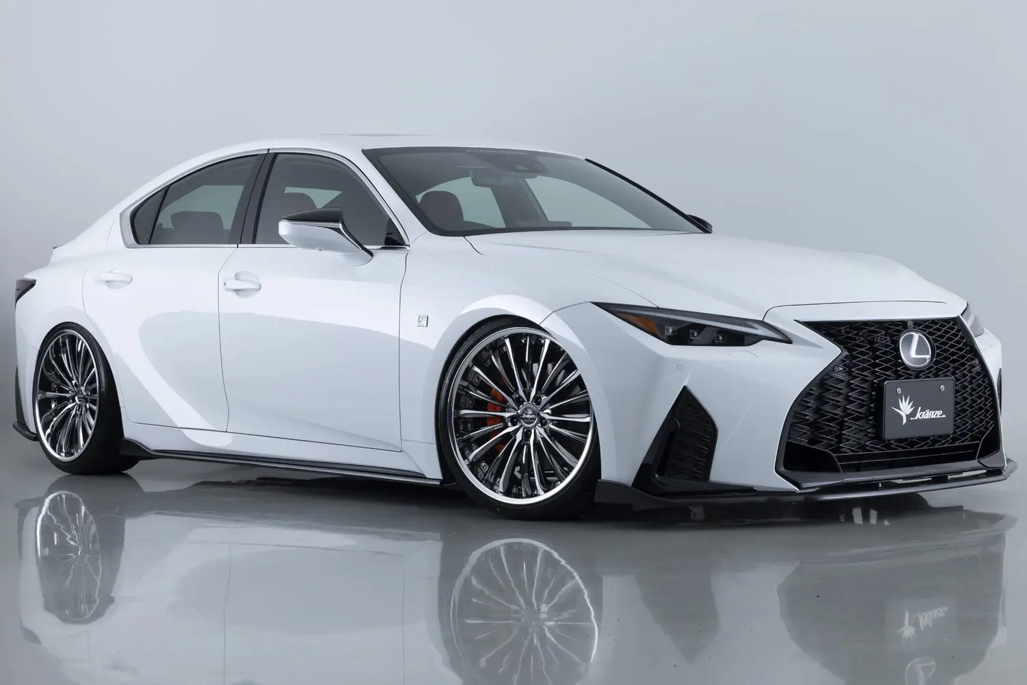 The white lexus rs is parked in a studio.
