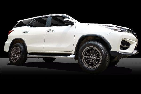 A white toyota fortuner suv on a black background.
