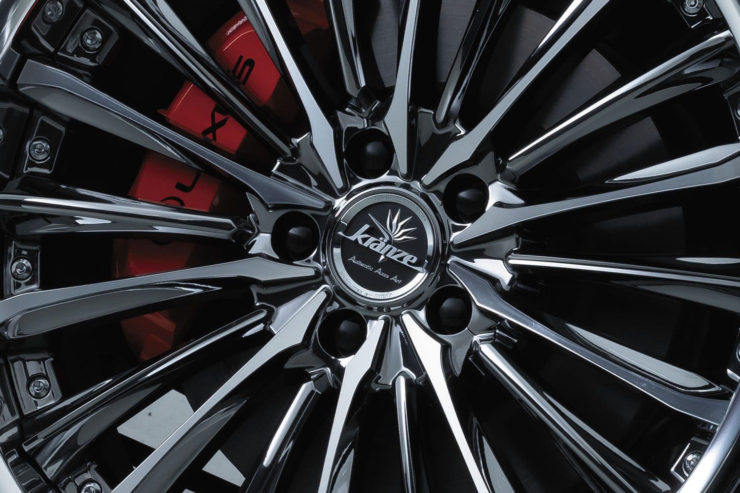 A close up of a chrome wheel with red accents.