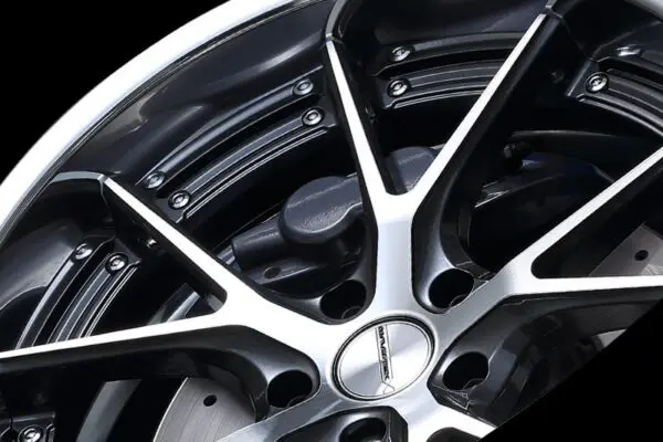 A close up of a black wheel with a chrome rim.