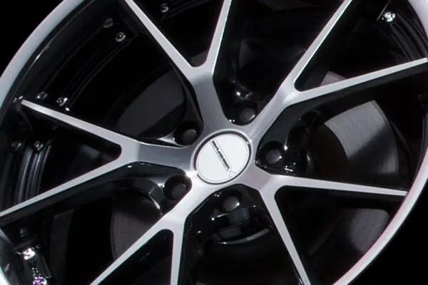 A close up of a black wheel on a black background.