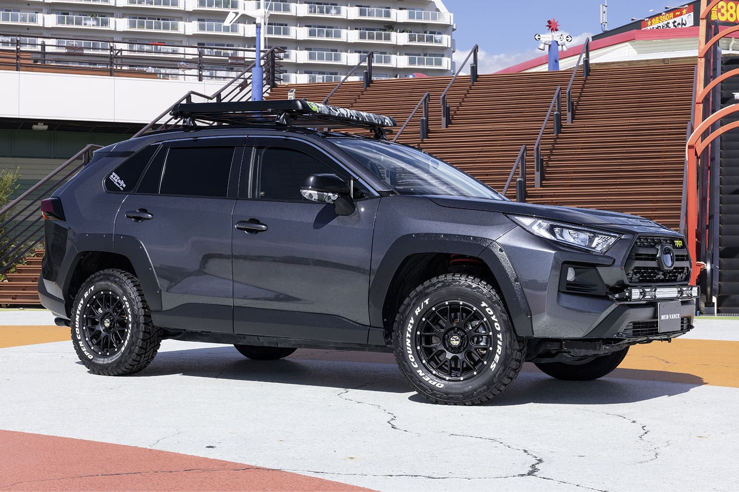 Gray SUV with roof rack and off-road tires.